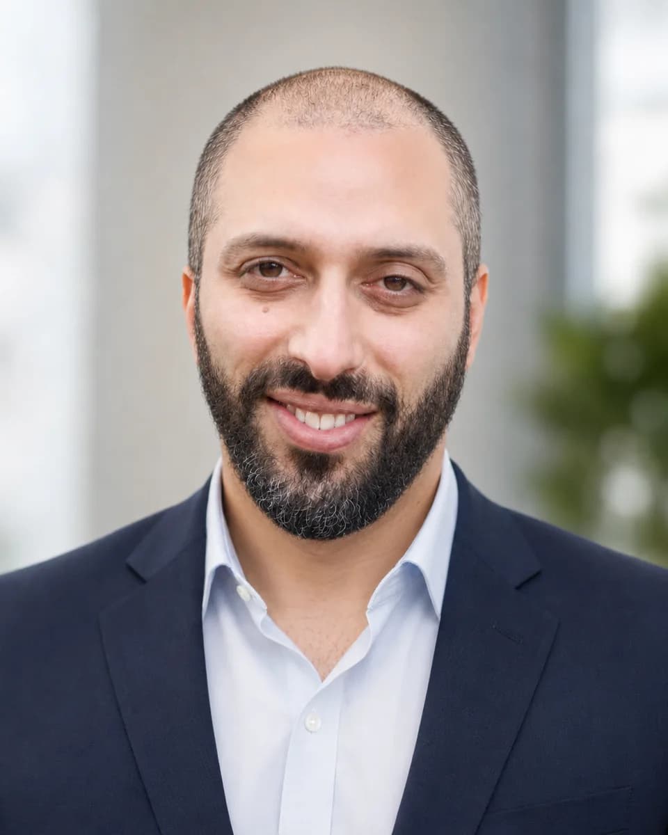 Thomas Meli, smiling, in a navy jacket.
